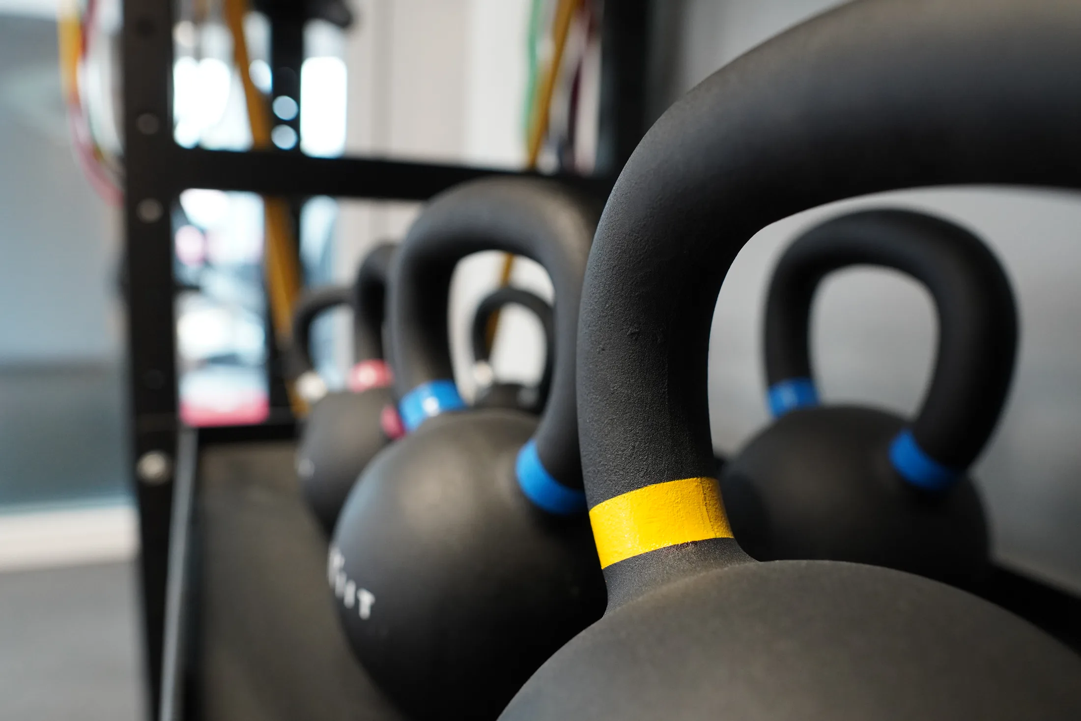 Kettlebells et élastiques de rééducation rangés sur le plateau technique