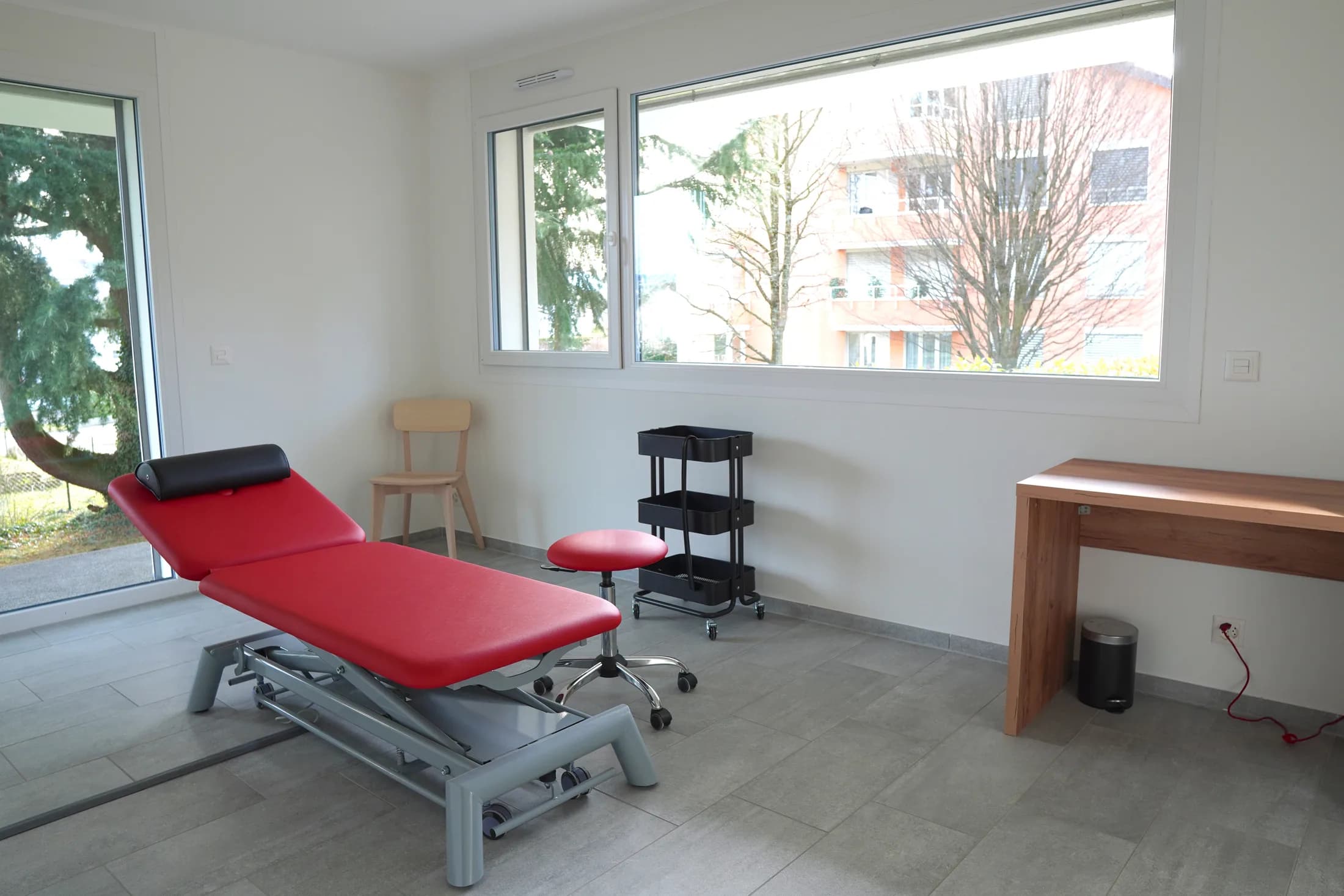Table de soins et tabouret réglable d’une salle de traitement individuelle