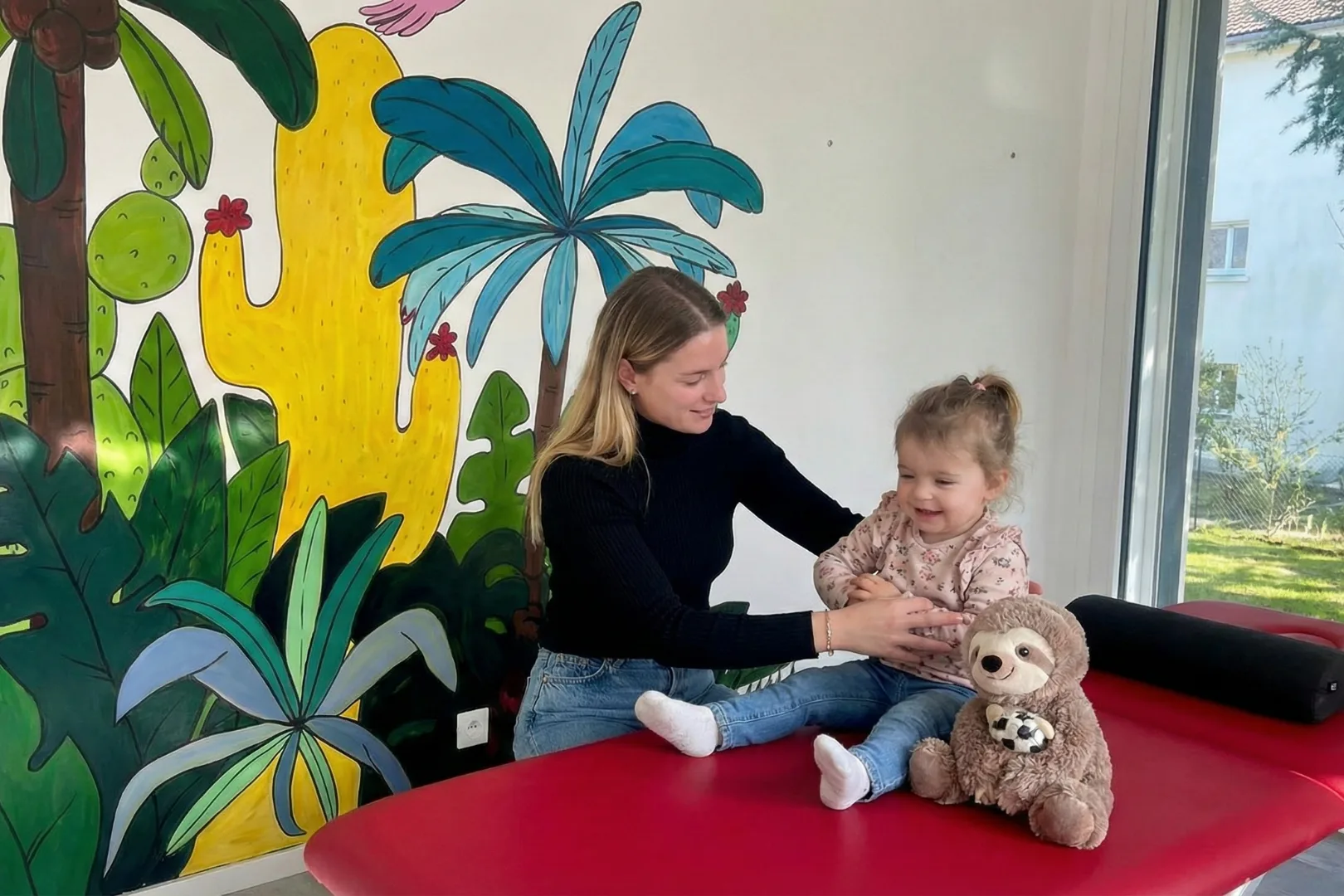 Séance de physiothérapie pédiatrique avec une jeune enfant, dans la salle dédiée du cabinet